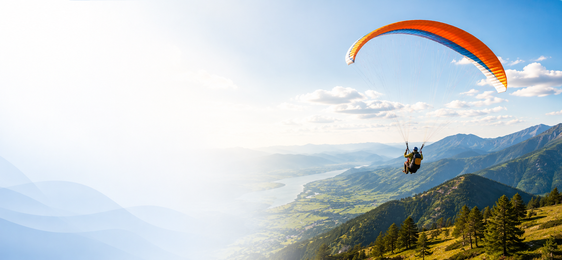 Paraglider soaring over a valley